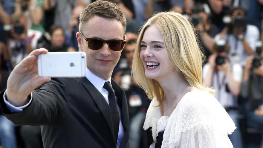 La actriz estadounidense Elle Fanning y el cineasta danés Nicolas Winding Refn (i), posan durante el pase gráfico de la película "The Neon Demon" en la 69 edición del Festival Internacional de Cine de Cannes.