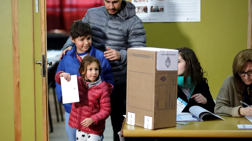 Un padre y sus dos hijos vota en uno de los centros de votación asignados para las elecciones Primarias para Presidente en la en la ciudad de Buenos Aires (Argentina), hoy domingo 11 de agosto del 2019.