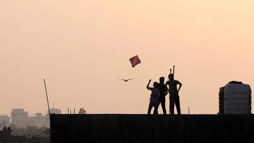 Un grupo de jóvenes hacen volar una cometa durante el aislamiento por el coronavirus en la ciudad de Nueva Delhi, India este lunes.