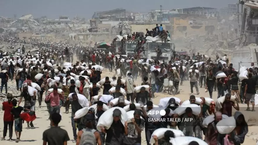 Miles de palestinos cargan sacos de harinas para alimentarse, tras entrada de camiones con ayuda humanitaria.