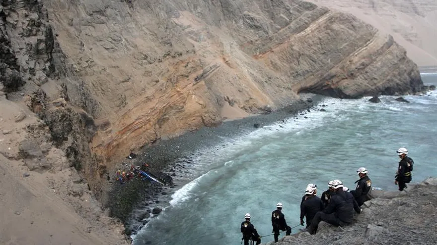 Un grupo de bomberos y policías participa en las labores de rescate de las víctimas de un autobús siniestrado el 2 de enero del 2017, en la carretera Panamericana Norte, a unos 45 kilómetros de Lima (Perú).