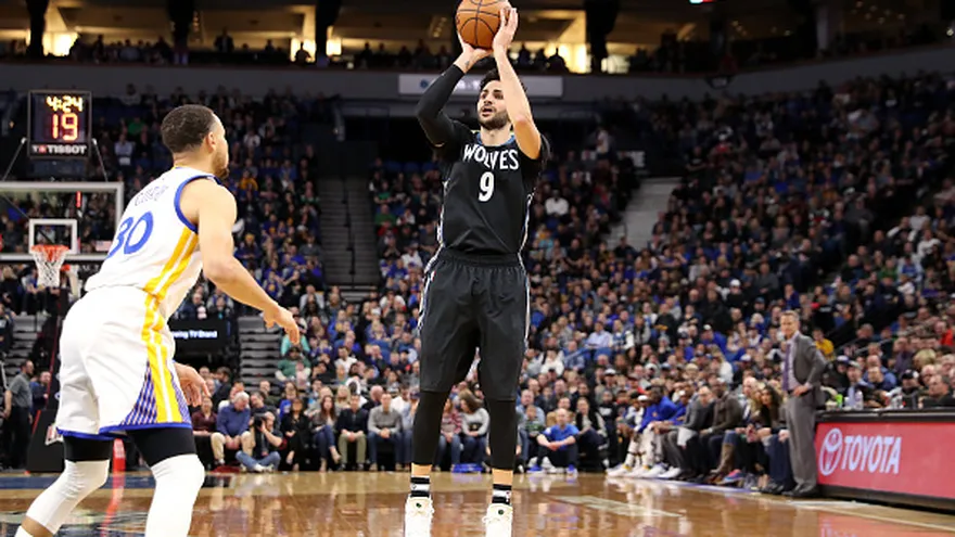 Ricky Rubio hace un tiro a la canasta ante la cobertura de Stephen Curry