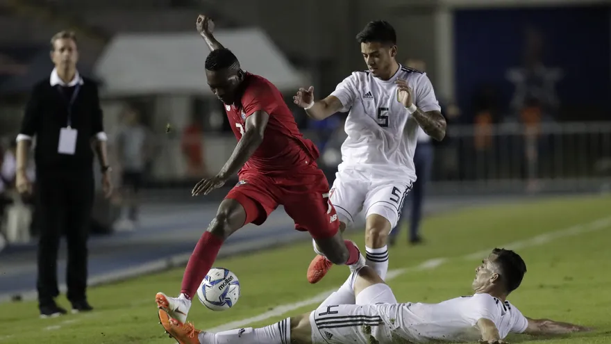 José Luis 'El Puma' Rodríguez conduce el balón ante jugadores venezolanos