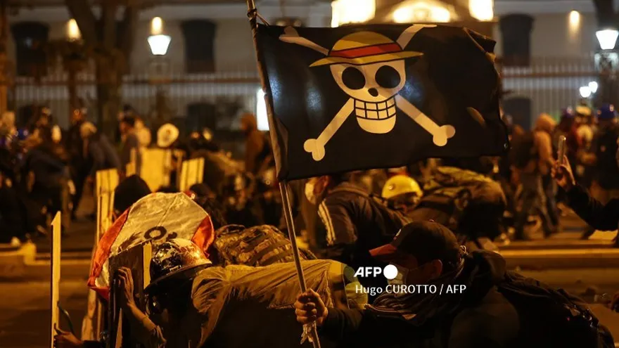 Manifestantes que sostienen una bandera de la serie de manga "One Piece" se enfrentan con agentes de la policía antidisturbios durante la protesta contra el presidente interino de Perú, José Jeri, en Lima el 15 de octubre de 2025.