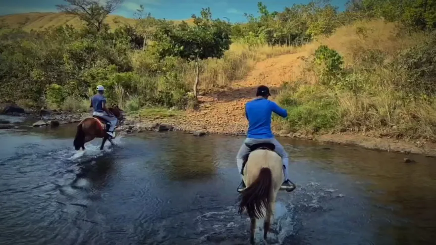 Personas cruzando a caballo un río en la comarca Ngäbe Buglé