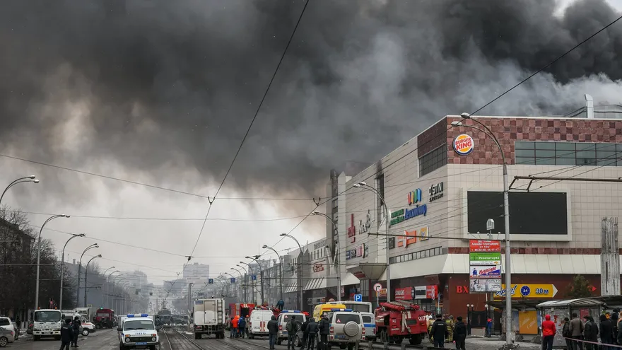 Policías rusos continúan con las labores de extinción del incendio originado ayer en el centro comercial en Siberia