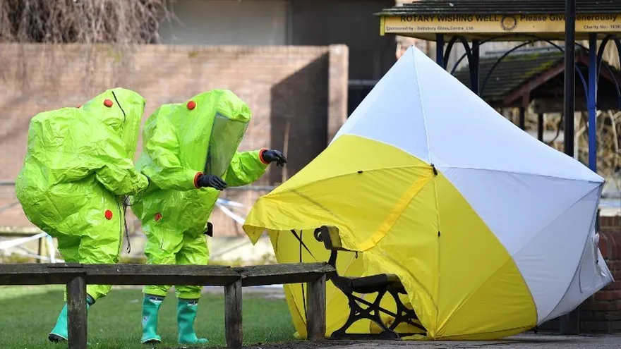 Miembros de los servicios de emergencia (en verde)  analizan la banca donde el espía ruso Sergei Skripal y su hija Yulia fueron encontrados en condición crítica.