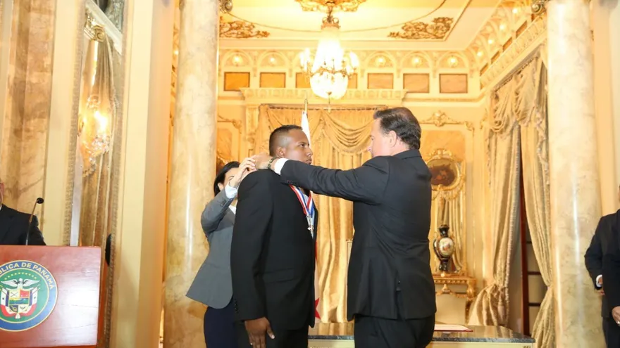 Momento en que el presidente Varela condecora al agente del Senan, Giorgio Marciano Valencia.