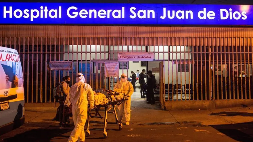 Paramédicos utilizan trajes de protección mientras trasladan a un paciente infectado con COVID-19 en el Hospital San Juan de Dios, en Ciudad de Guatemala (Guatemala).