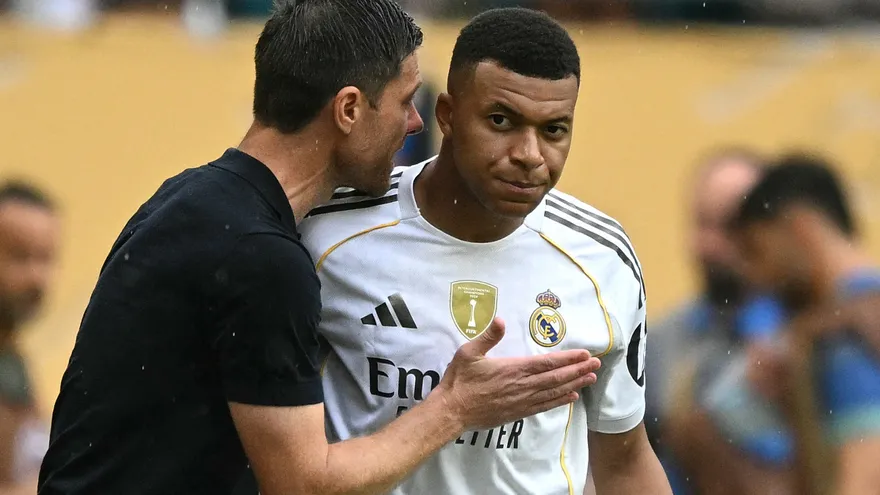Xabi Alonso (i) da instrucciones a Kylian Mbappé (d)