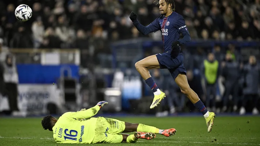 Bradley Barcola salta sobre el portero Donovan Leon durante el partido entre el PSG y el Auxerre