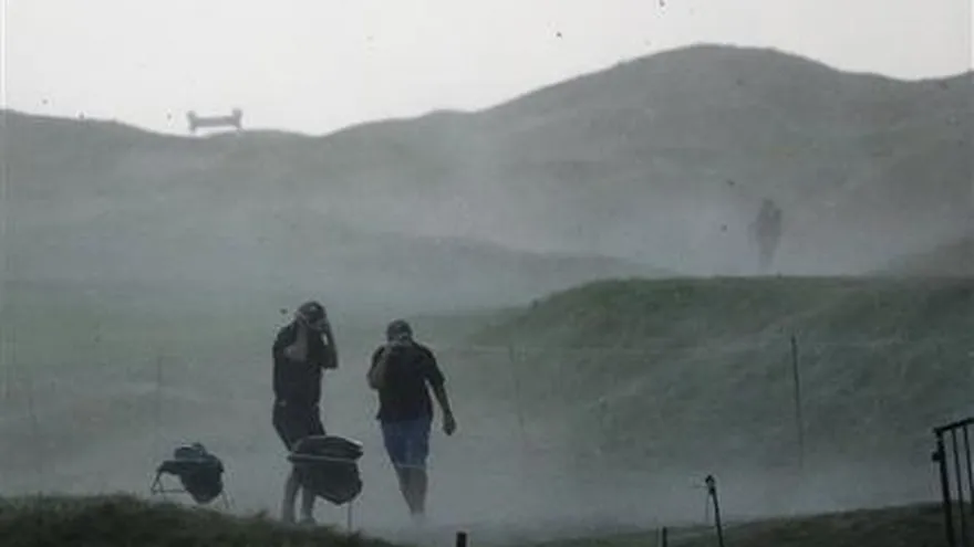 Un grupo de espectadores busca guarecerse de la llegada de una tormenta durante la segunda ronda del PGA Champinship, el viernes 14 de agosto de 2015