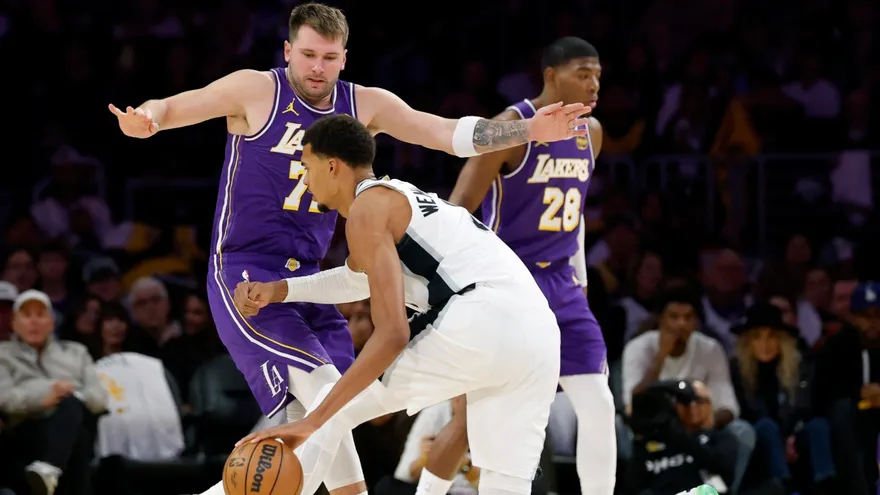 Luka Doncic (de frente) intent evitar el avance de Victor Wembanyama