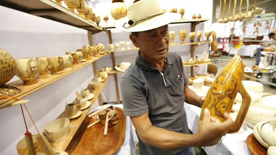 El artesano pirograbador panameño Milciades Morales muestra un grabado de Marilyn Monroe sobre un güiro musical, en la Feria Nacional de Artesanías.