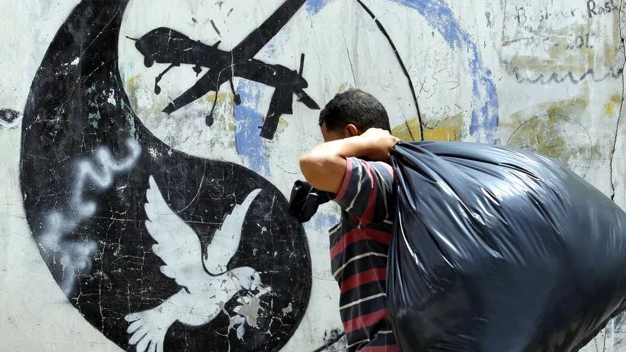 Foto ilustrativa: Un hombre pasa delante de un grafiti alusivo a un supuesto ataque de las fuerzas estadounidenses contra una rama de Al Qaeda, en Saná (Yemen)
