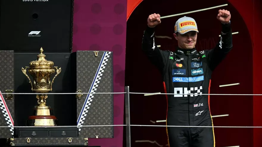 Lando Norris (i) celebra cerca del trofeo del Gran Premio de Gran Bretaña