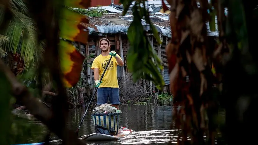 Fotografía fechada el 26 de julio, que muestra a voluntarios de Trash Hero en tablas de paddleboard mientras recogen basura de un canal en Samutprakarn, en las afueras de Bangkok (Tailandia).