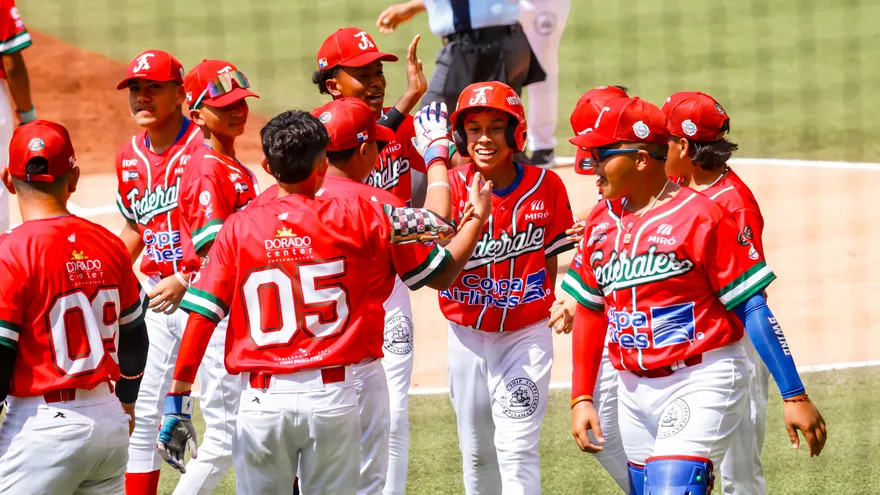 Noah Araúz (c) es felicitado por sus compañeros durante el partido de la Serie del Caribe Kids 2026 entre Panamá (Federales de Chiriquí) y Puerto Rico