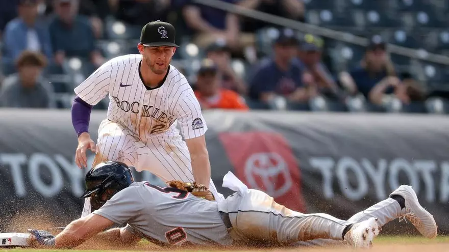 Ryan McMahon trata de sacar un out en la tercera base