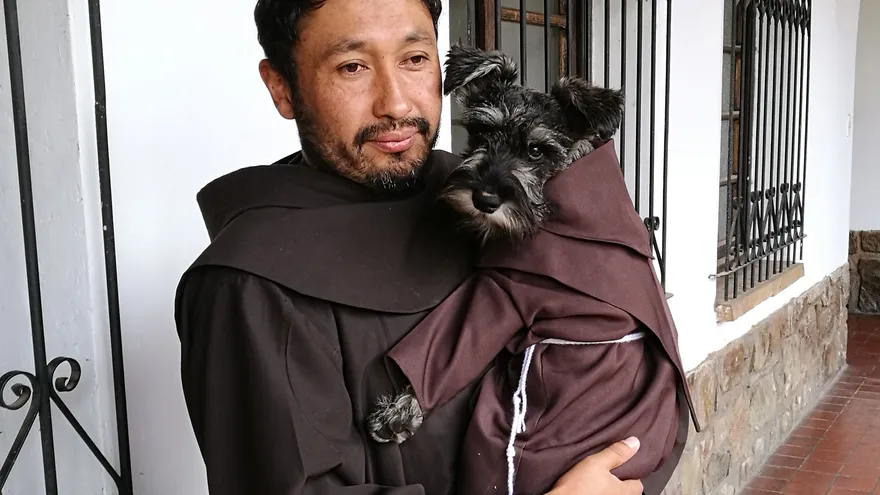 Fotografía sin fechar cedida por el religioso polaco y profesor de teología Kasper Kapron, en la que se observa al franciscano, Jorge Fernández, quien sostiene al can "Fray Carmelo", la mascota del convento de los franciscanos en Cochabamba (Bolivia)