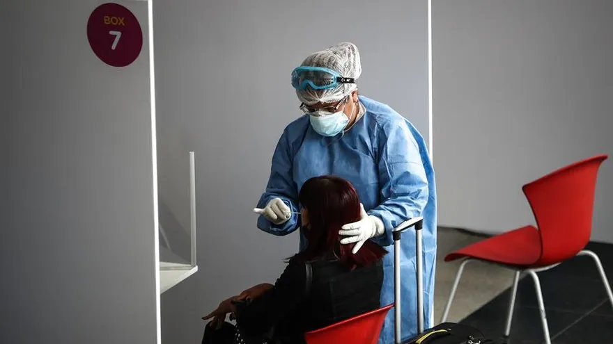 Personal sanitario realiza una prueba de coronavirus a una viajera en Buenos Aires