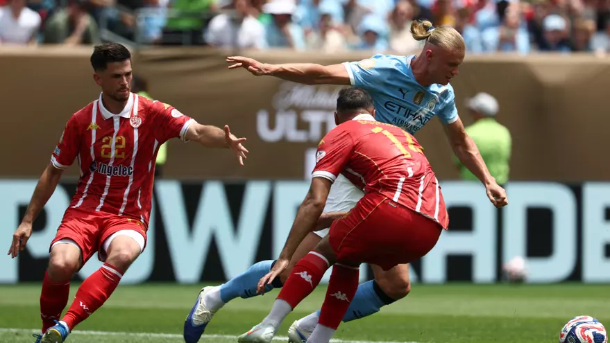 Erling Haaland trata de evadir a dos jugadores del Wydad Casablanca