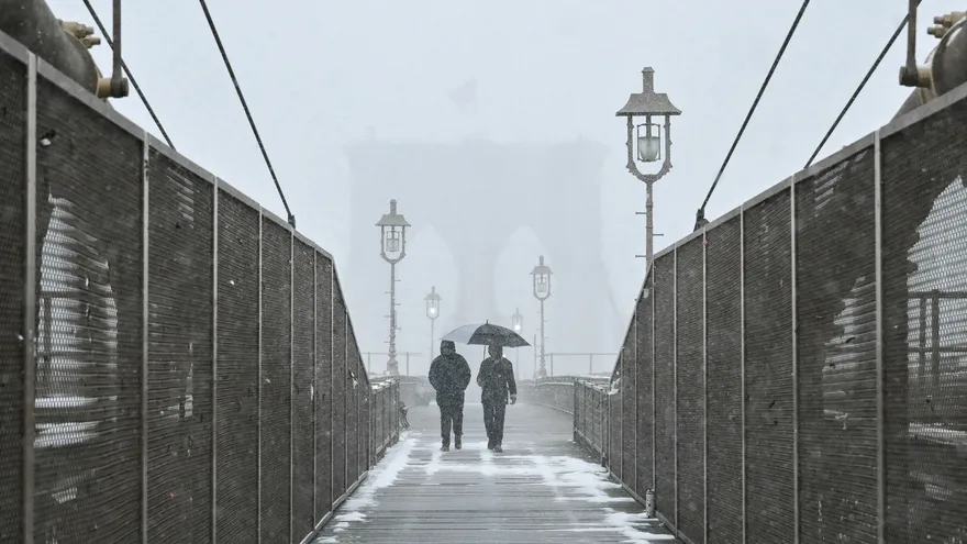 Personas caminan por el puente de Brooklyn en medio del clima invernal