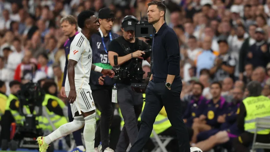Vinicius (i) se cruza con  Xabi Alonso (d) a su salida del campo durante el partido entre el Real Madrid y el Barcelona