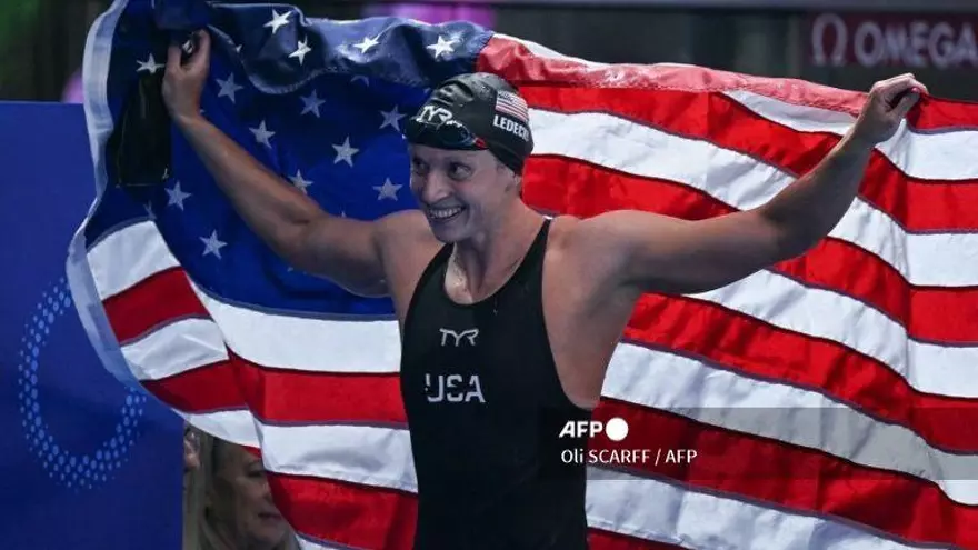 La nadadora estadounidense Katie Ledecky celebra con la bandera de Estados Unidos después de ganar la final de la prueba de natación estilo libre femenina de 1500 m durante el Campeonato Mundial de Acuáticos de 2025 en Singapur el 29 de julio de 2025.