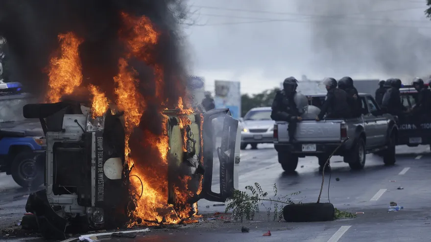 Fotografía de un vehículo policial en llamas hoy, domingo 2 de septiembre de 2018