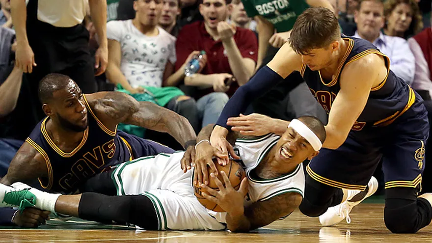 Isaiah Thomas (acostado), LeBron James (i) y Kyle Korver (d) disputan el balón