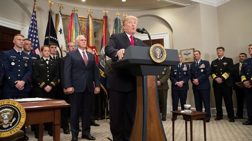 El presidente estadounidense, Donald Trump (d), ofrece una rueda de prensa junto al vicepresidente, Mike Pence (d) y personal de Defensa, tras la firma de la Ley de Autorización de Defensa Nacional para el Año Fiscal 2018.