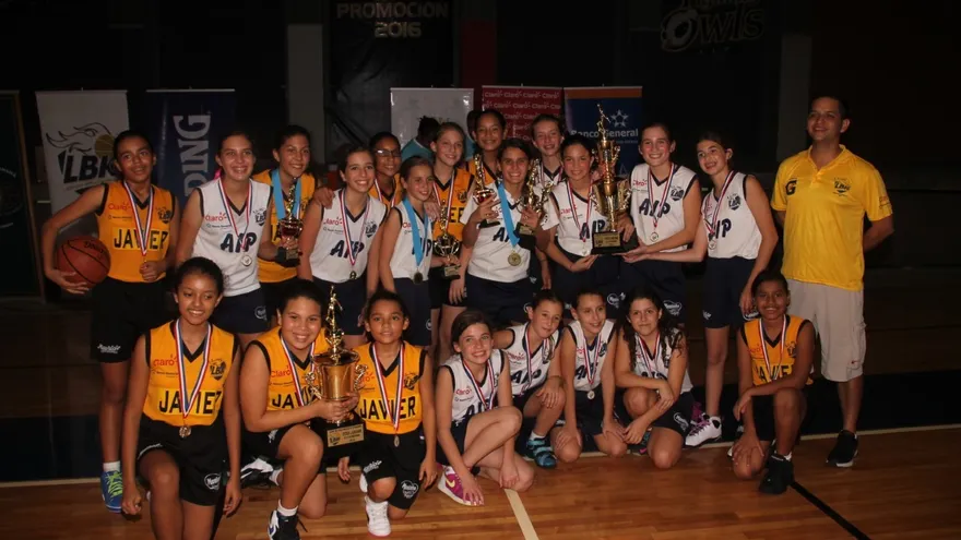 Jugadoras de las AIP Owls y el Colegio Javier posan juntas con sus respectivos galardones