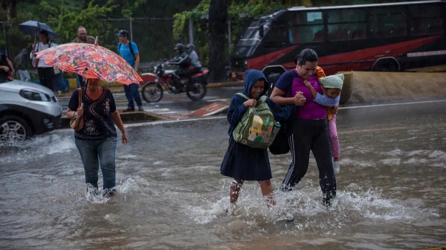 Unos peatones caminan por una calle inundada de Caracas, Venezuela
