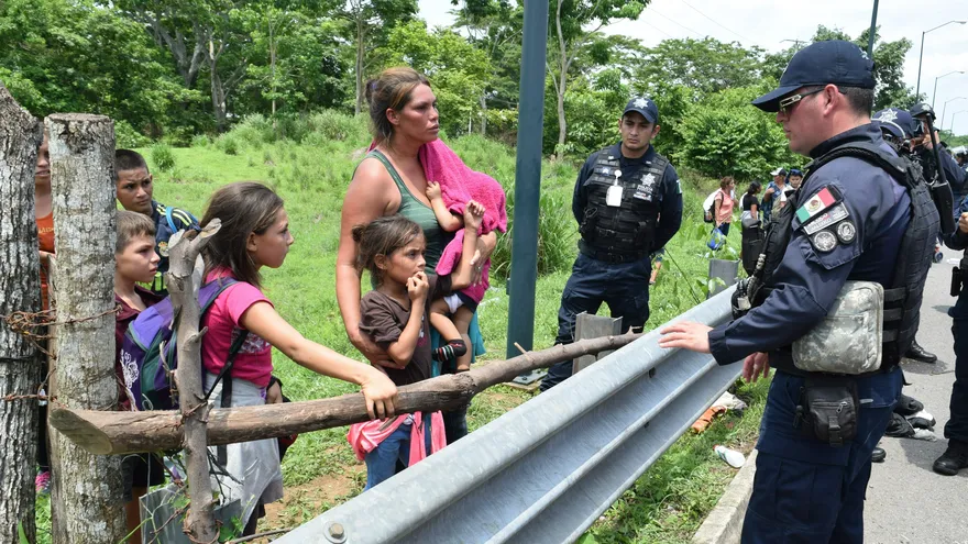 Policías intentan persuadir a una familia de migrantes centroamericanos que viajaba en caravana que fue interceptada para evitar que continuara su trayecto por territorio mexicano
