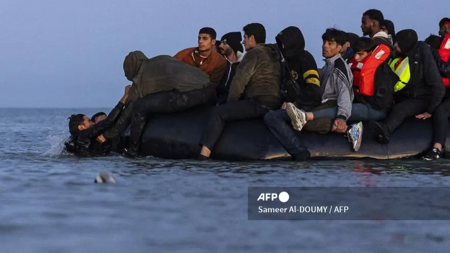 Los migrantes intentan abordar un barco de contrabando en un intento de cruzar el Canal de la Mancha frente a la playa de Gravelinas, en el norte de Francia.