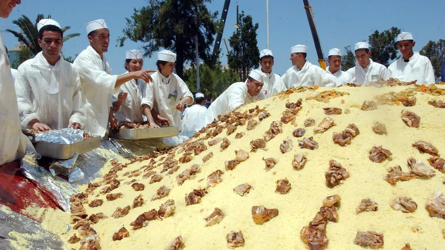 Cocineros argelinos aplican los toques finales a su cuscús en la feria de Argel