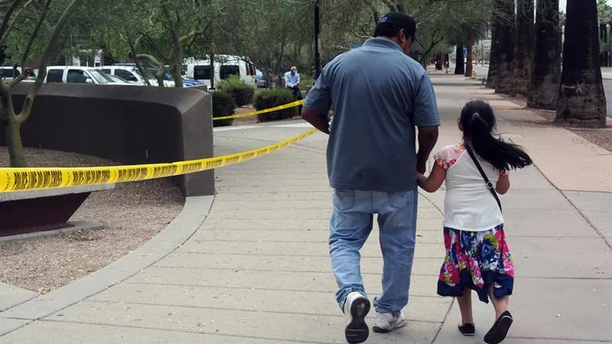 Un hombre camina junto a su hija tras salir de una cita en la Oficina de Control de Inmigración y Aduanas (ICE) en Phoenix, Arizona (EE.UU.).