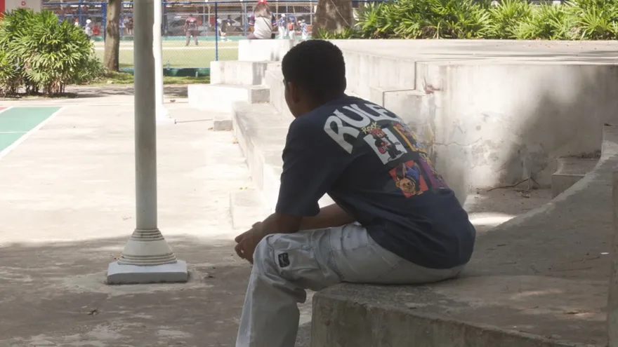 Un niño se sienta solo en un parque