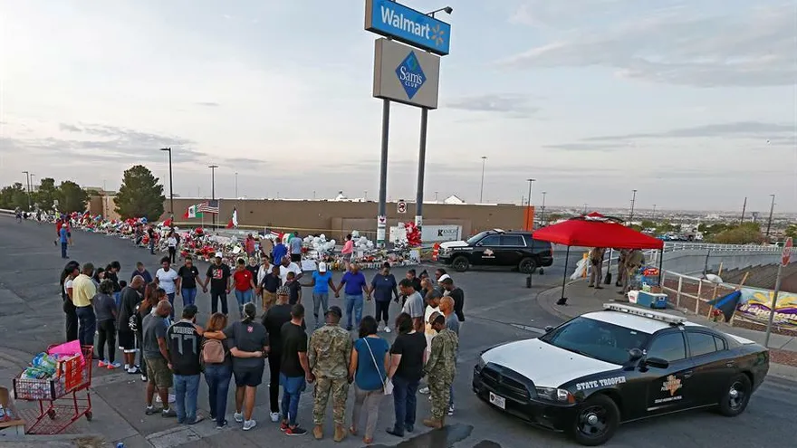 Un grupo de personas realizan un homenaje a las víctimas de la matanza de El Paso, en el lugar en que sucedieron los hechos.