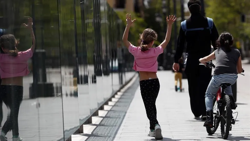 Niños pasean con un adulto por Madrid, este domingo en el que se cumplen 43 días de confinamiento y en el que más de seis millones de niños menores de 14 años pueden salir a la calle una hora al día, junto a un adulto y a un kilómetro como máximo de sus casas