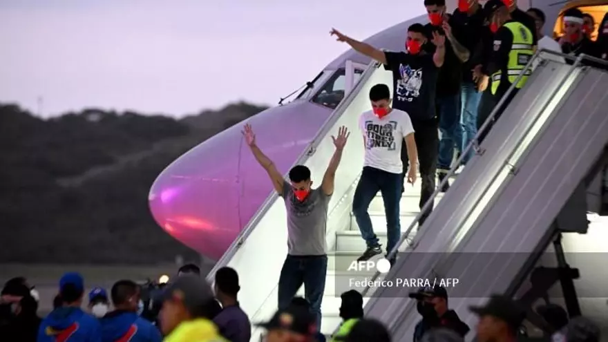 Los migrantes arribaron en dos aviones al aeropuerto que sirve a Caracas. Vestidos de civil con un tapabocas rojo, varios bajaron la escalinata con los brazos en alto