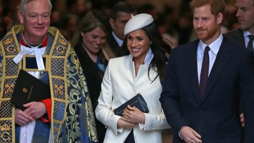El reverendo  David Stanton (i),el Príncipe Harry  (d) y su primetida, la actriz  Meghan Markle (C) abandonan la iglesia luego de la misa de conmemoración del  Commonwealth Day en la Abadía de  Westminster en el centro de Londres.