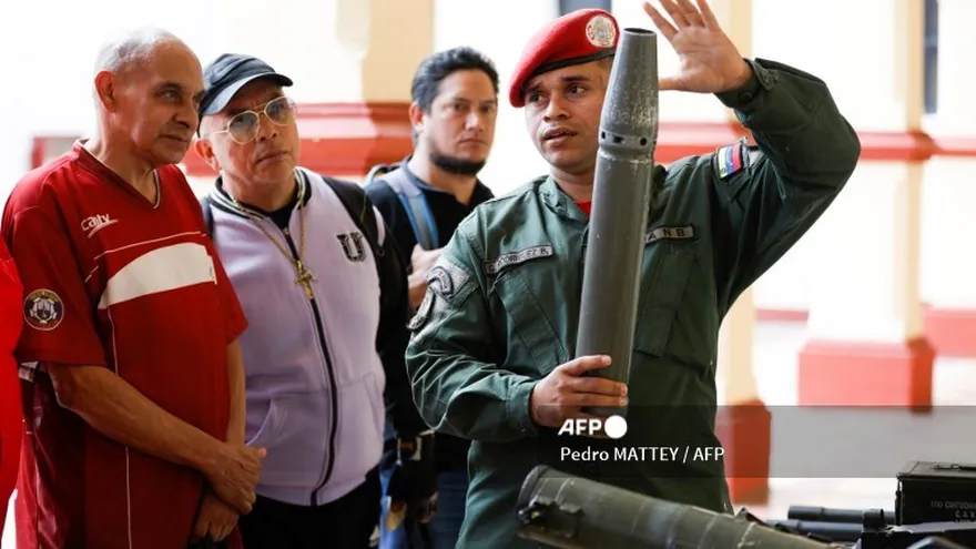 Un soldado venezolano explica a un grupo de jubilados el uso de un proyectil.