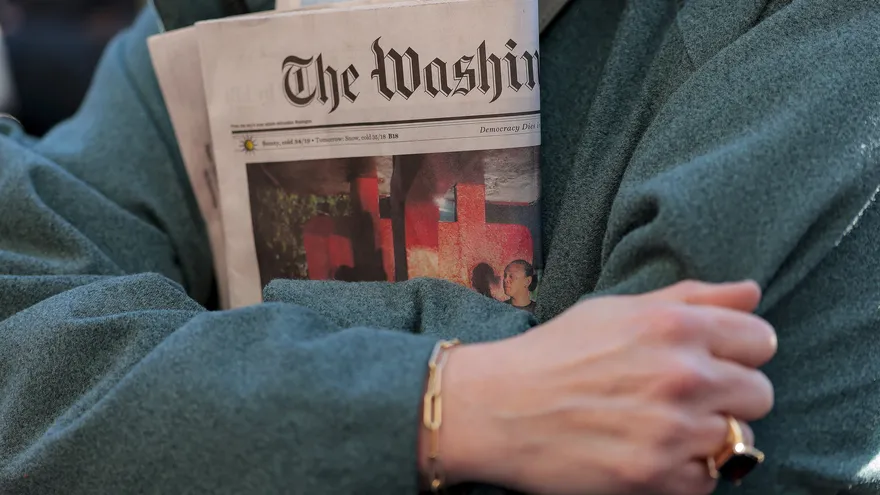 Una persona sostiene una edición impresa del diario The Washington Post