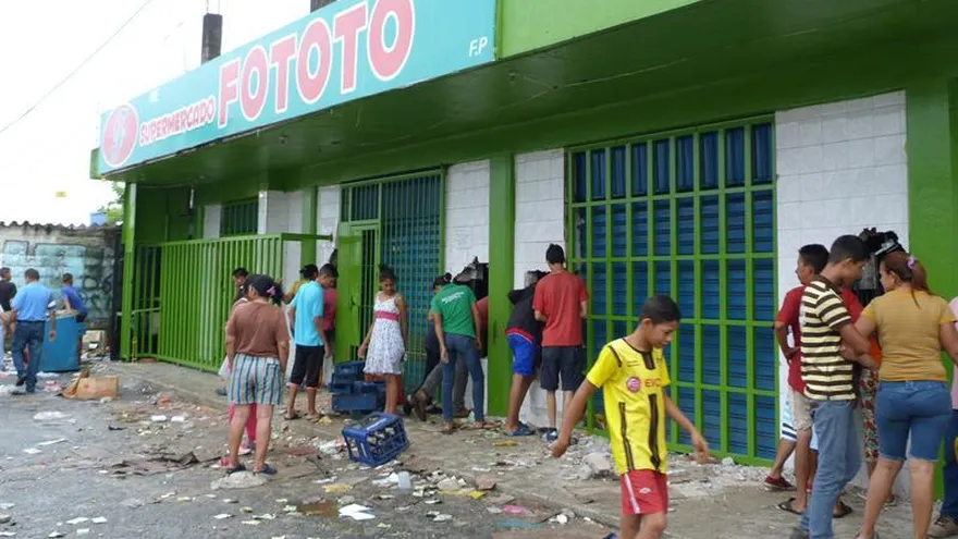 Fotografía del 23 de mayo del 2017, donde se observa un grupo de personas frente a locales comerciales que fueron saqueados en la ciudad de Barinas (Venezuela).