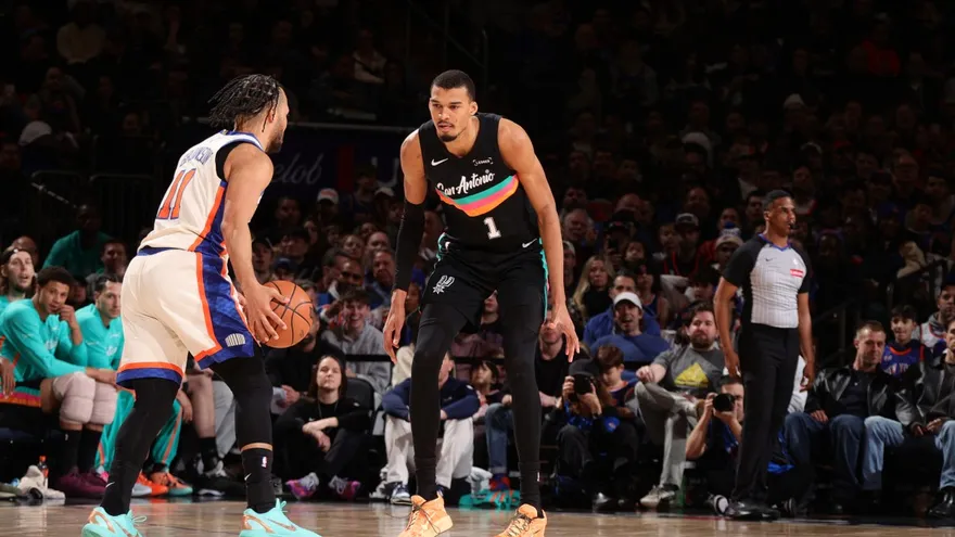 Victor Wembanyama (de frente) hace la cobertura defensiva a Jalen Brunson