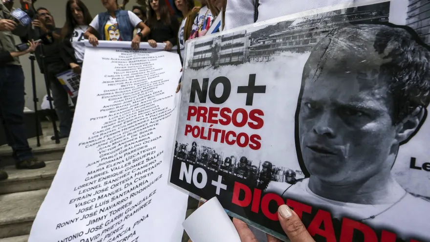 La esposa del dirigente opositor Leopoldo López, Lilian Tintori (c-arriba), desplegó ayer una pancarta con una lista de los más de 100 presos políticos en Caracas (Venezuela)