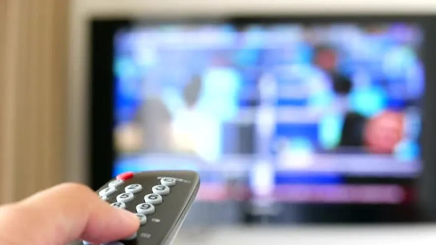 Imágen con fines ilustrativos de una persona usando un mando de televisión