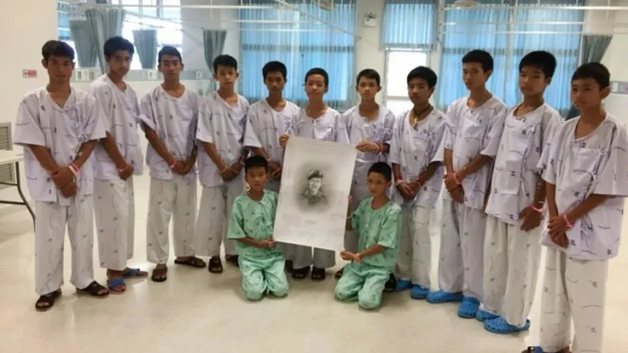 Los niños tailandeses posan en el hospital Prachanukroh de Chiang Rai junto con una foto del buzo fallecido durante su operación de rescate, el 14 de julio de 2018. © Chiang Rai Prachanukroh Hospital/AFP/Archivos Handout